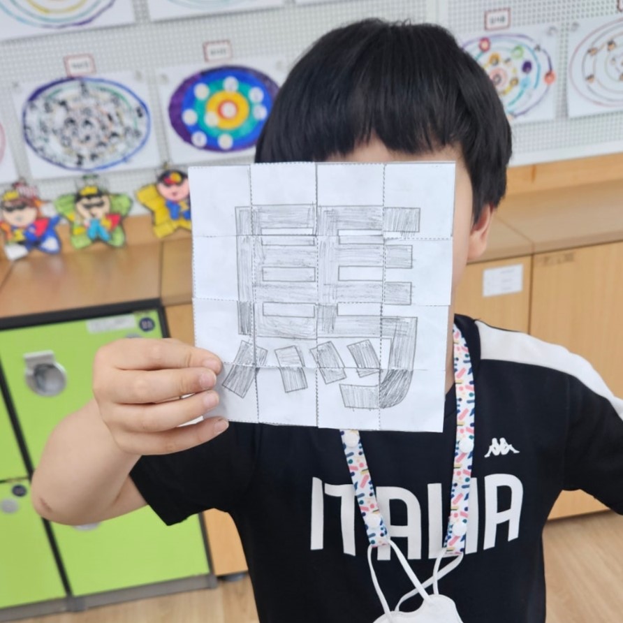 "참여형 한문 수업 활동으로 한자 글자 퍼즐을 직접 맞추며 성취감을 느끼는 초등학생의 환한 모습"